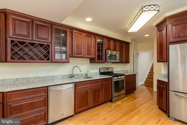 a kitchen with stainless steel appliances granite countertop a stove a sink dishwasher and a refrigerator