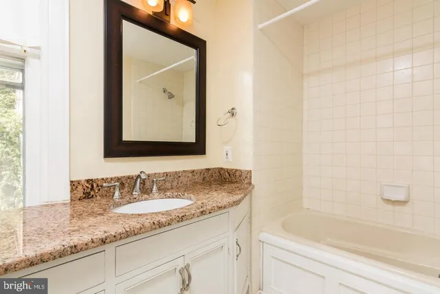 a bathroom with a granite countertop sink and a mirror