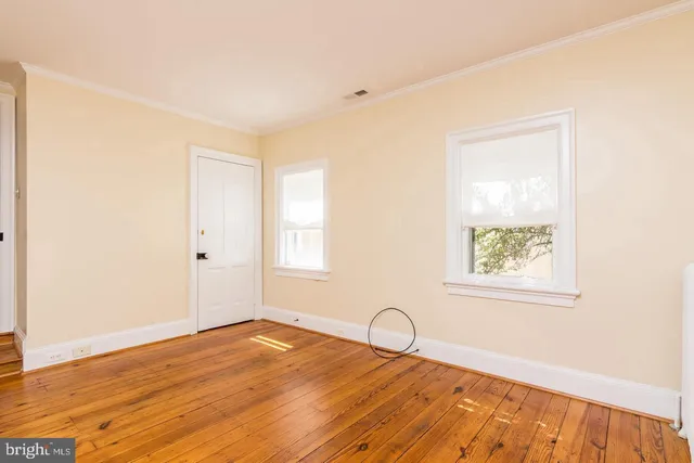 a view of a room with wooden floor and a window