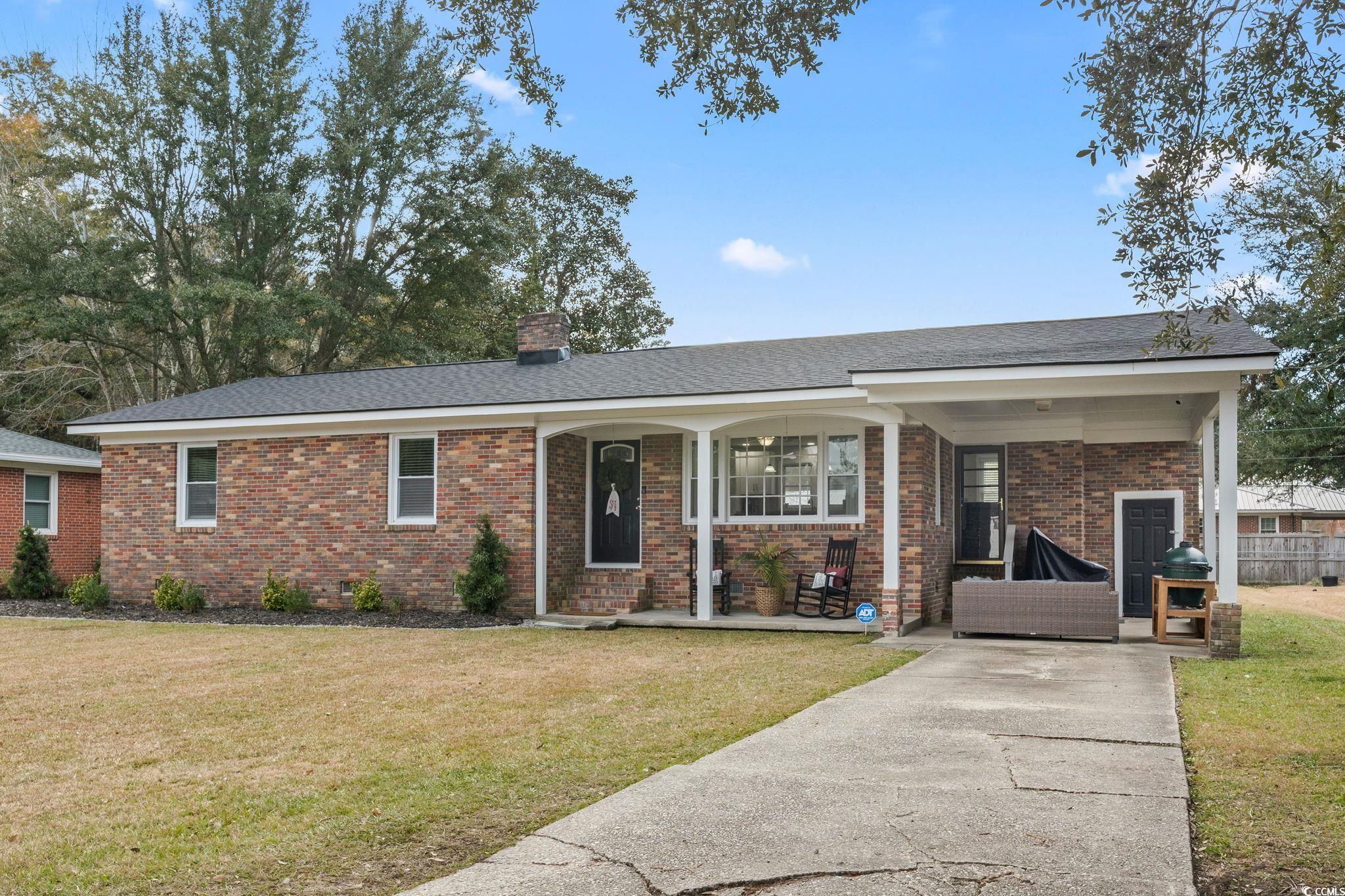 Single story home featuring a porch and a front ya