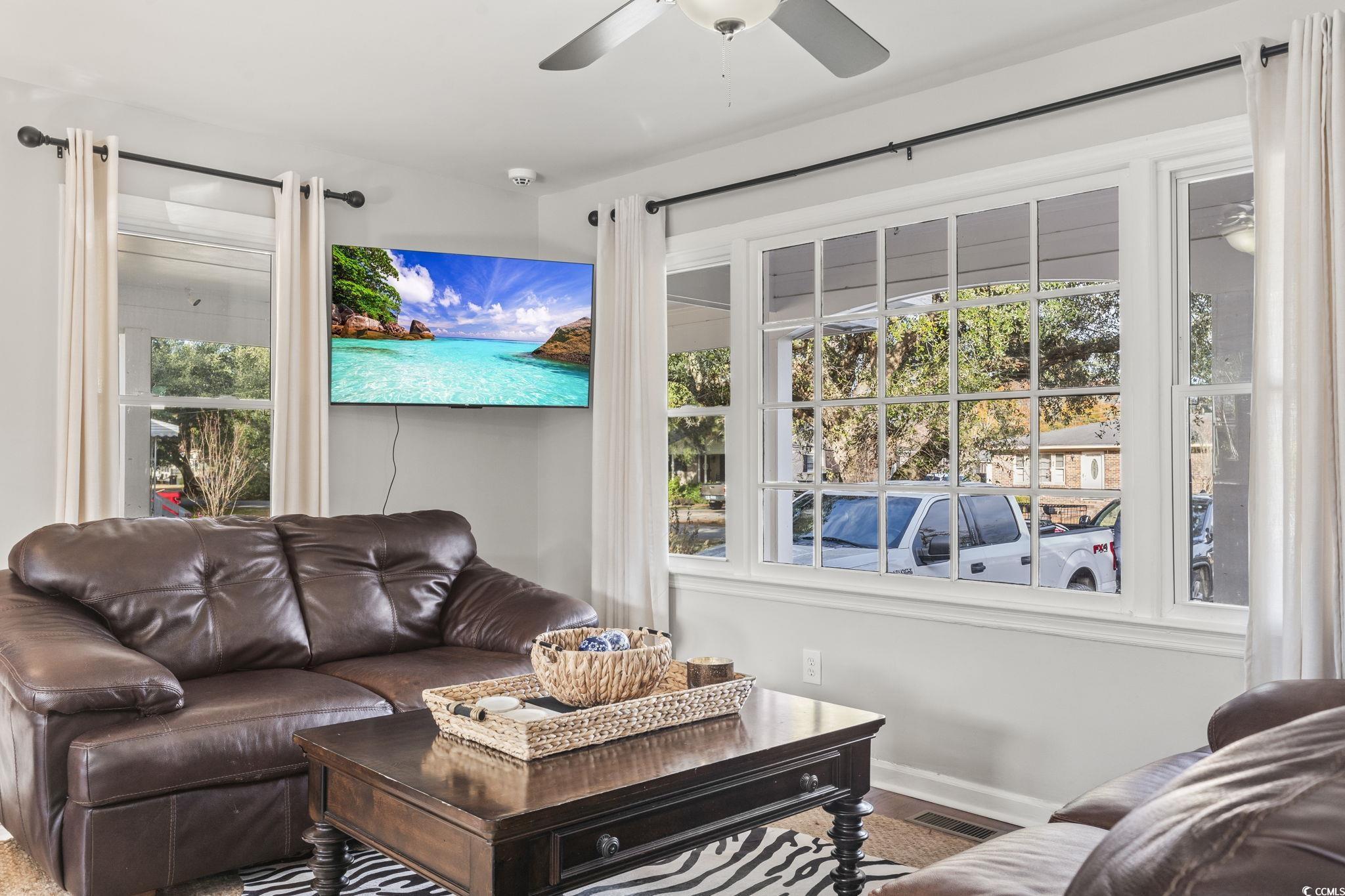 Living room featuring ceiling fan and hardwood / w