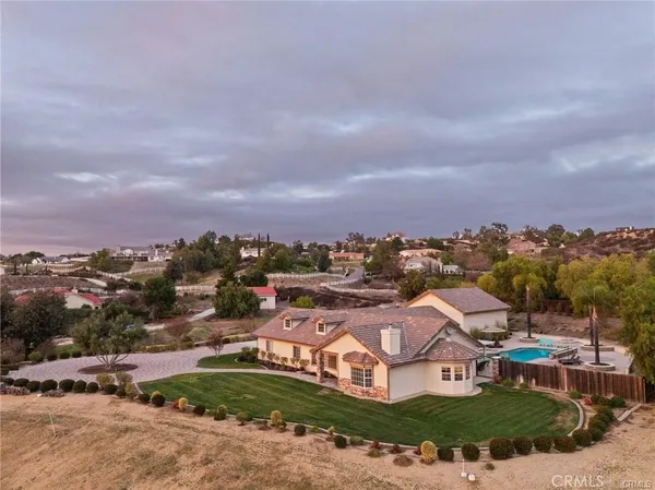 an aerial view of residential houses with outdoor space and trees