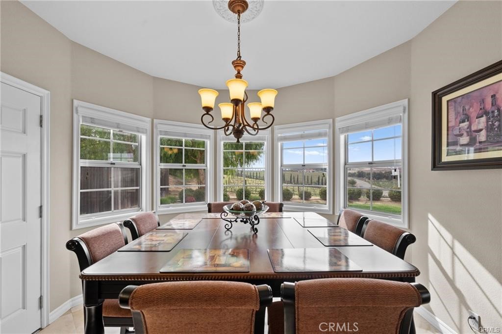 39581 Sperry Court Temecula, CA 92591 - Photo 20 of 63 a view of a dining room with furniture large windows and wooden floor