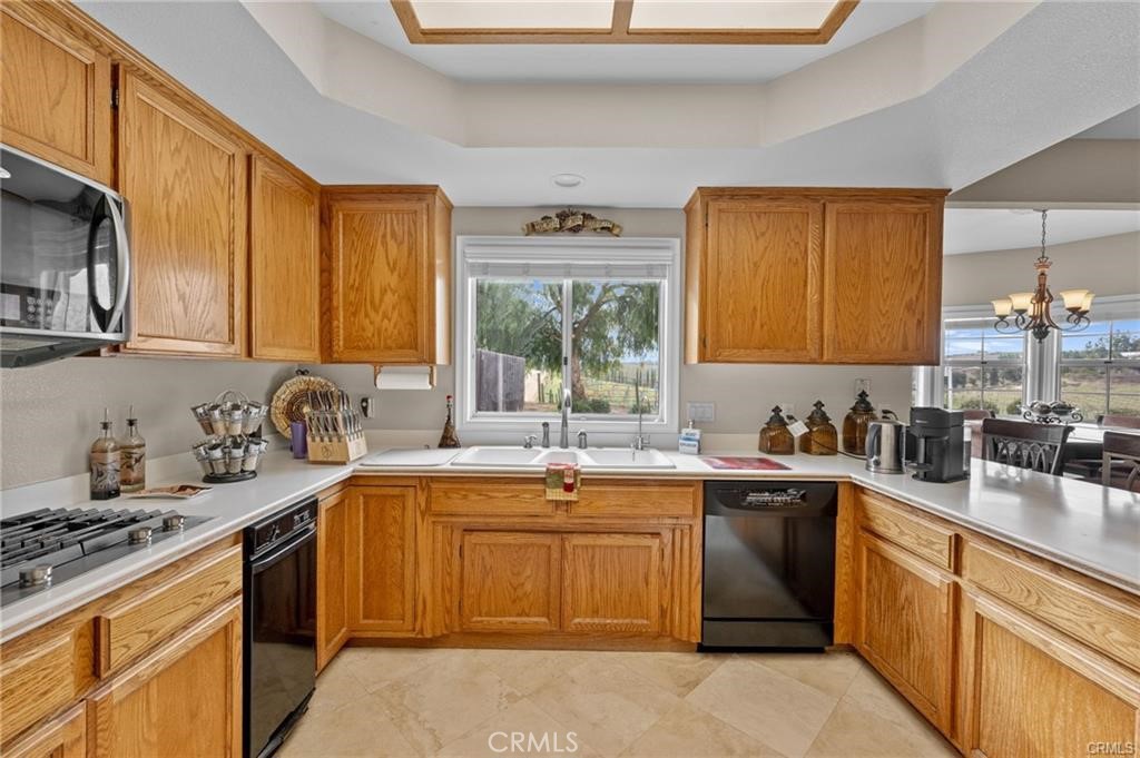 39581 Sperry Court Temecula, CA 92591 - Photo 25 of 63 a kitchen with a sink stove top oven and cabinets