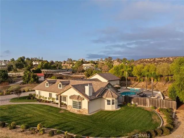 an aerial view of residential houses with outdoor space and trees