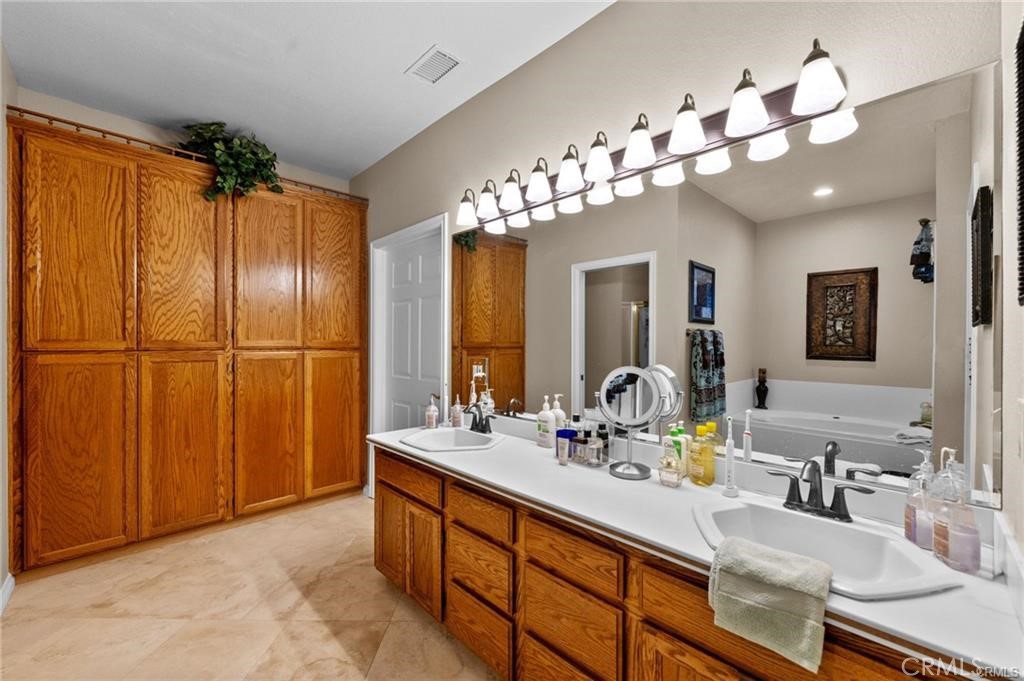 39581 Sperry Court Temecula, CA 92591 - Photo 33 of 63 a bathroom with a double vanity sink and a mirror