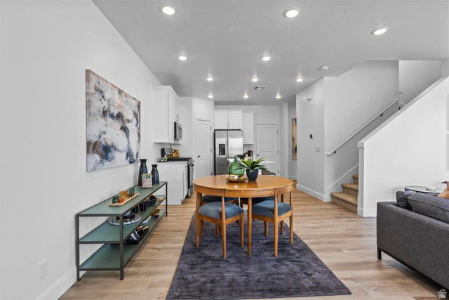 488 West Greenstone Pl Street, Unit 1010 St. George, UT 84790 - Photo 7 of 34 Open-concept living space featuring wood-finish flooring, recessed lighting, white walls, and a staircase with a white handrail