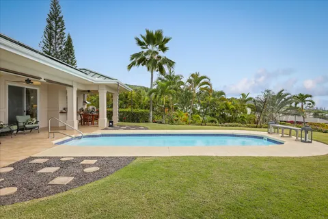 a view of a swimming pool with a lawn chairs and plants
