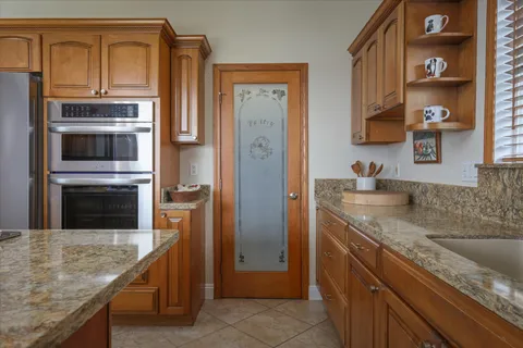 a kitchen with stainless steel appliances granite countertop a refrigerator and a stove