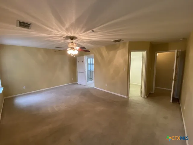 an empty room with fan and entrance