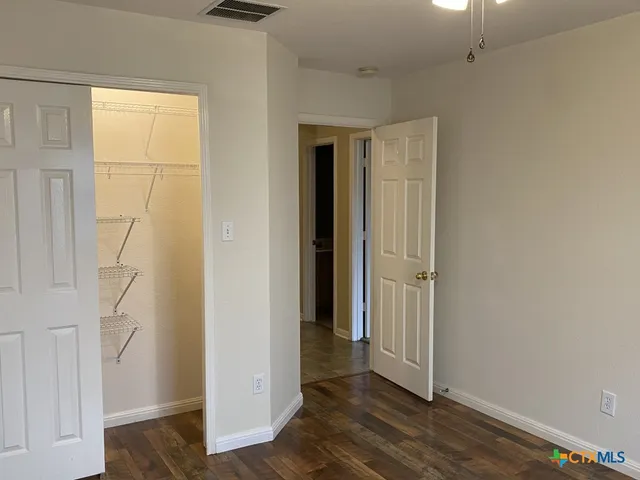 an empty room with wooden floor and closet