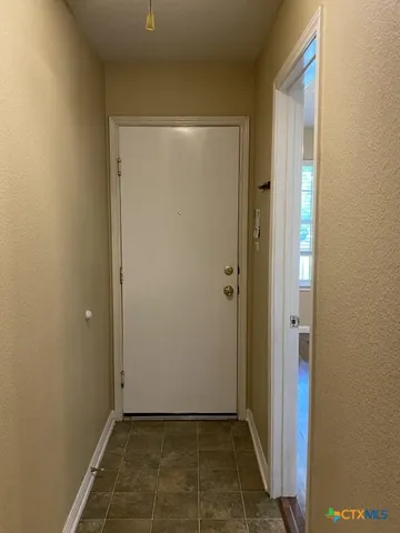 an empty room with wooden floor chandelier fan and windows