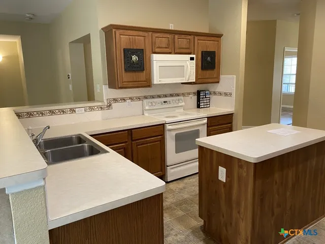 a kitchen with a stove a sink and a refrigerator