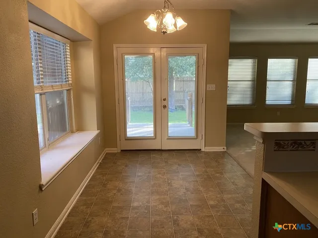 a view of an empty room with a fireplace and a window