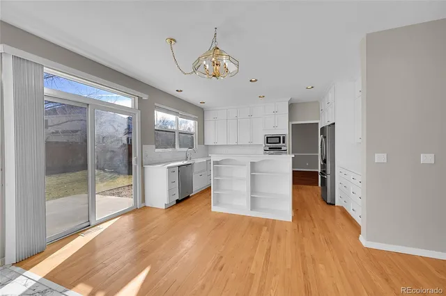 a large kitchen with stainless steel appliances granite countertop a lot of counter space and wooden floor