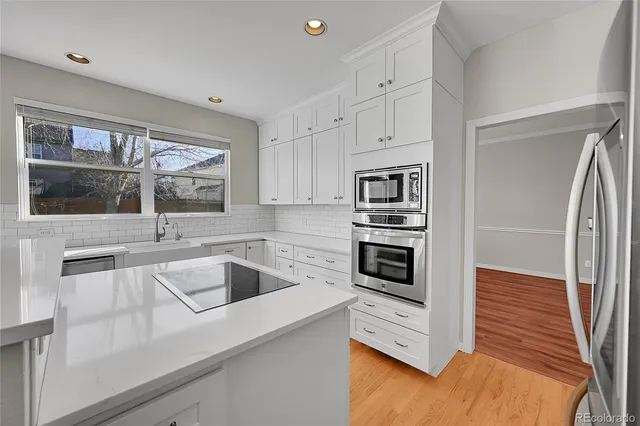 a kitchen with a sink a microwave and cabinets