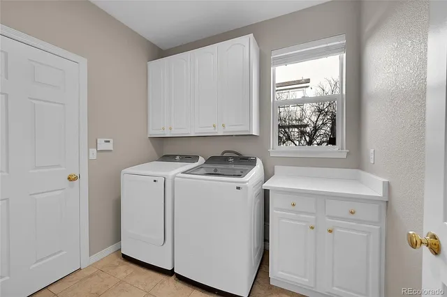 a view of washer and dryer with white cabinets