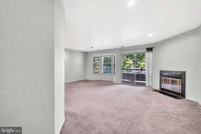 a view of an empty room with a fireplace and a window