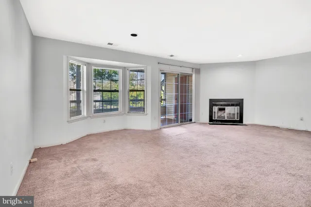 an empty room with a window and fireplace