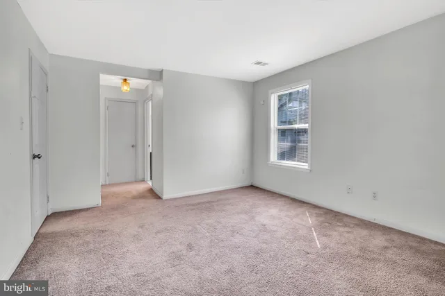 an empty room with windows and closet