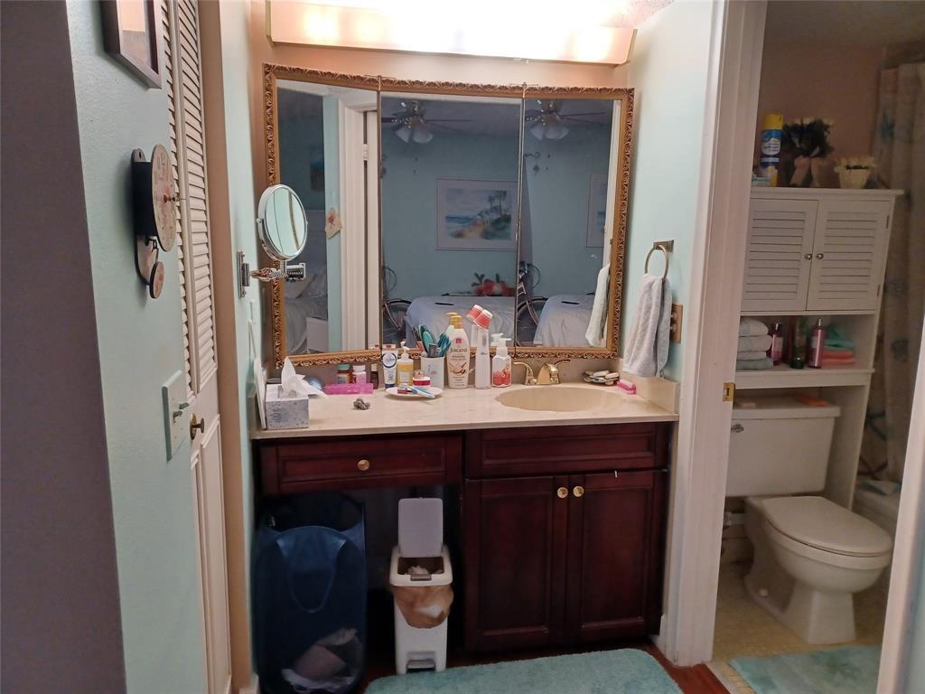 2901 Fiore Way, Unit 107 Delray Beach, FL 33445 - Photo 6 of 13 a bathroom with a toilet sink and mirror