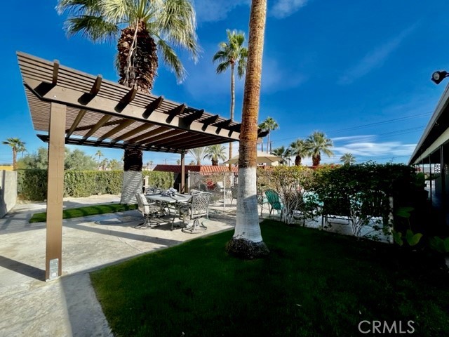 37111 Cathedral Canyon Drive, Unit 1 Cathedral City, CA 92234 - Photo 17 of 19 a view of a patio with table and chairs potted plants with floor to ceiling window