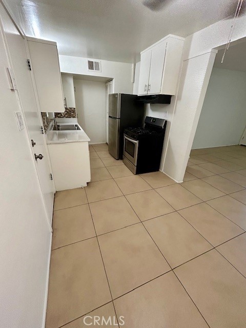 37111 Cathedral Canyon Drive, Unit 1 Cathedral City, CA 92234 - Photo 6 of 19 a kitchen with cabinets and black appliances