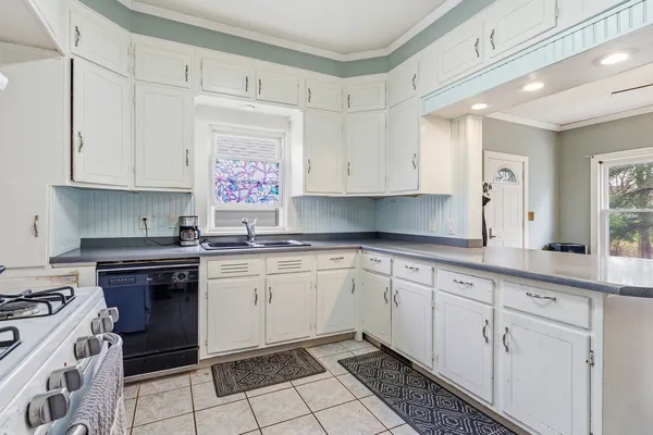 a kitchen with granite countertop white cabinets and white appliances