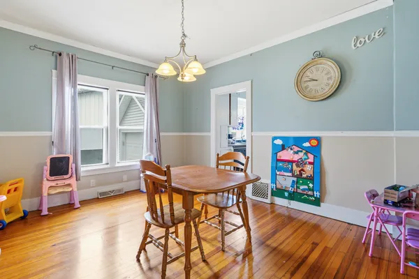 a view of a dining room with furniture wooden floor and a chandelier