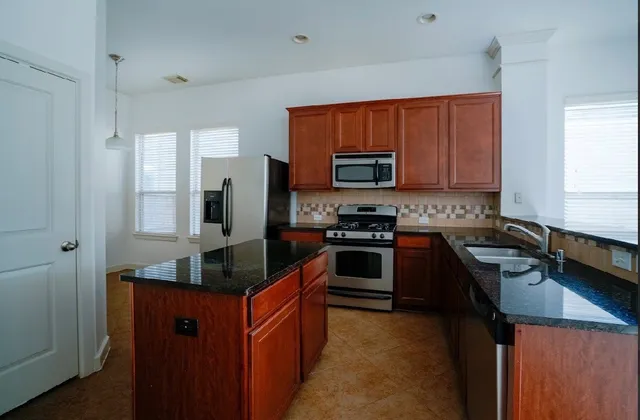 a kitchen with granite countertop stainless steel appliances and wooden cabinets