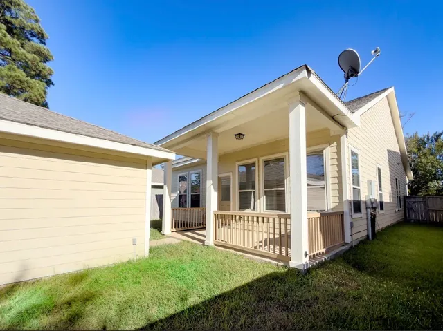 a view of house with backyard and trees in the background