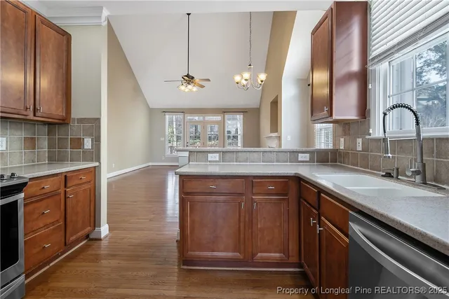a kitchen with stainless steel appliances granite countertop a sink a stove and cabinets