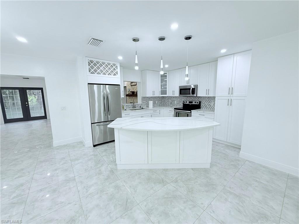 3330 13th Avenue Southwest Naples, FL 34117 - Photo 30 of 50 a view of kitchen with refrigerator stove microwave and cabinets