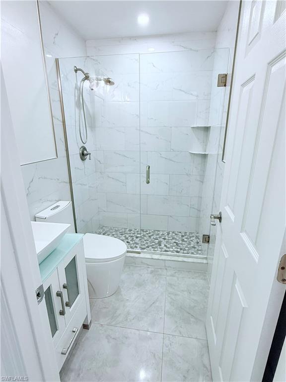 3330 13th Avenue Southwest Naples, FL 34117 - Photo 38 of 50 a bathroom with a granite countertop shower and a toilet