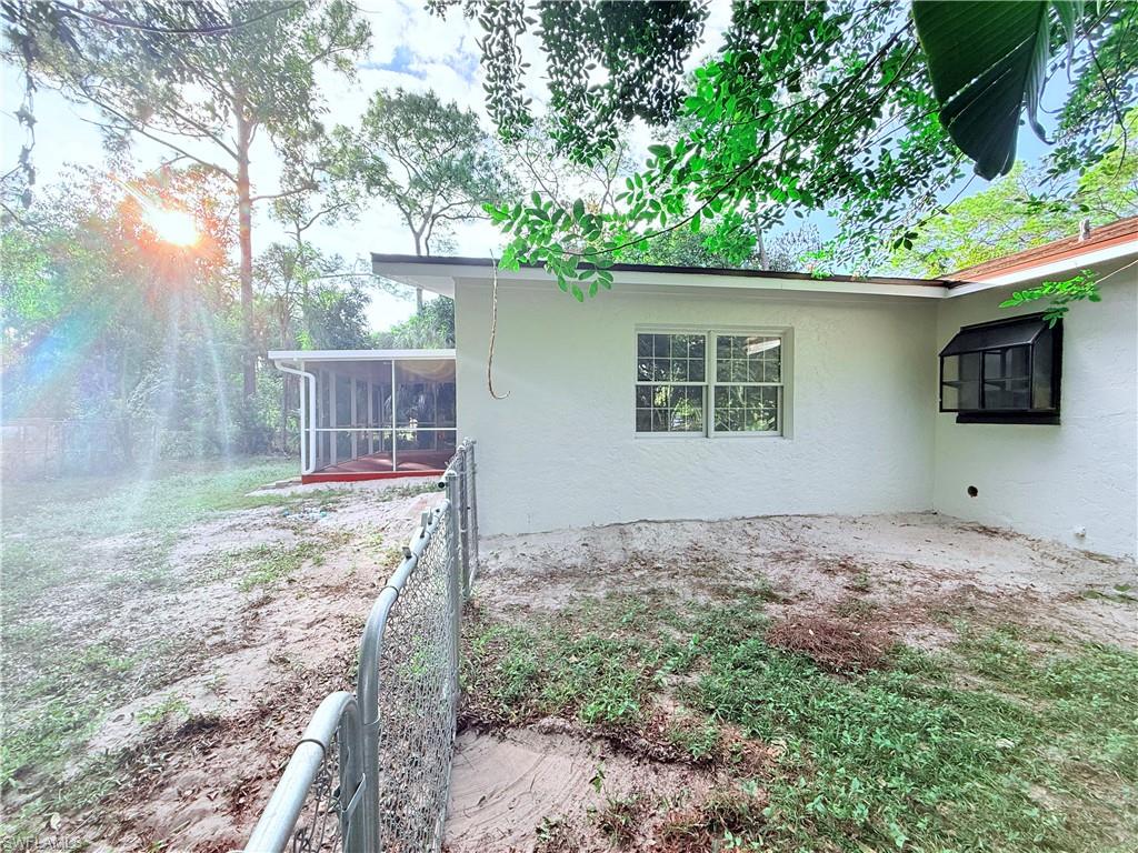 3330 13th Avenue Southwest Naples, FL 34117 - Photo 9 of 50 a view of a backyard with a tree and wooden fence