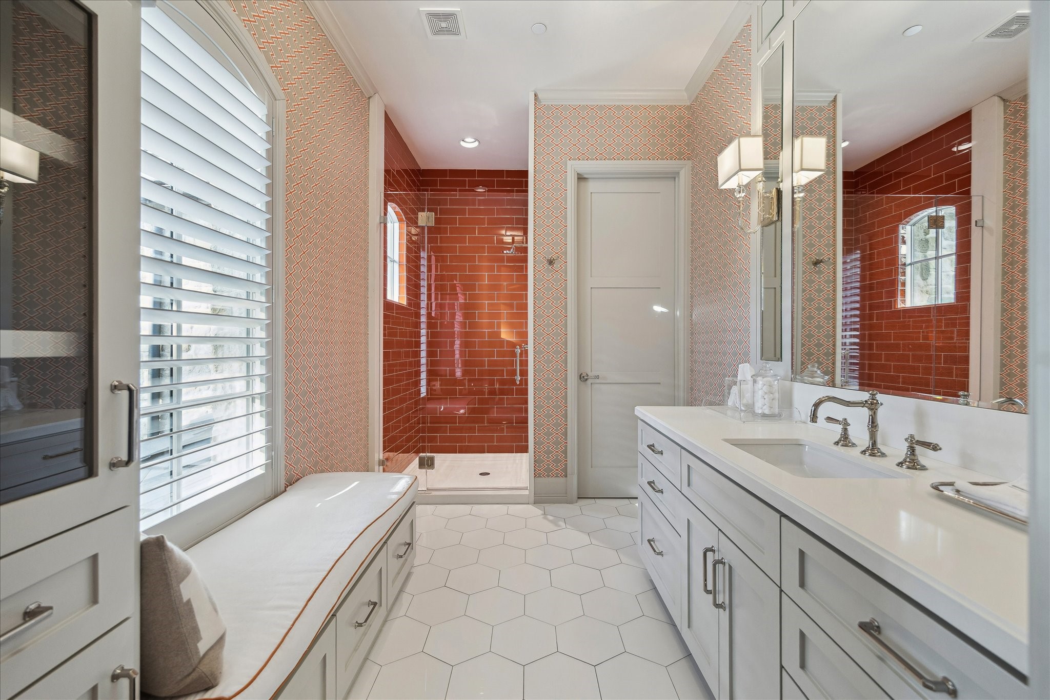 220 Merrie Way Lane Houston, TX 77024 - Photo 41 of 50 A beautifully layered bathroom with hex tile flooring, marble vanity, built-in bench, Segreto-plastered ceiling, designer wallpaper, and a walk-in shower finished in striking orange tile.