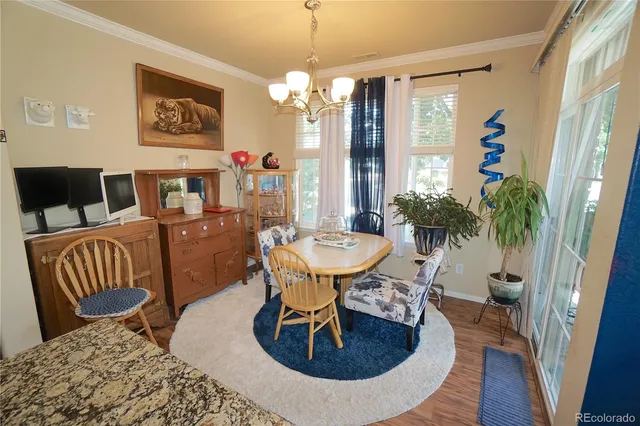 a view of a dining room with furniture a chandelier and wooden floor