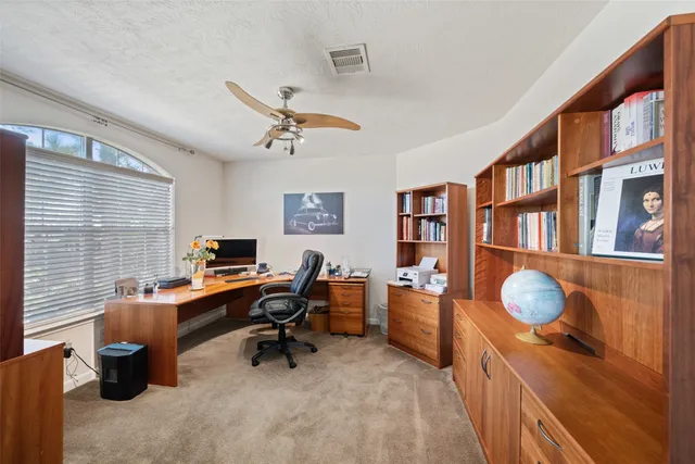 a view of a workspace with furniture and a window