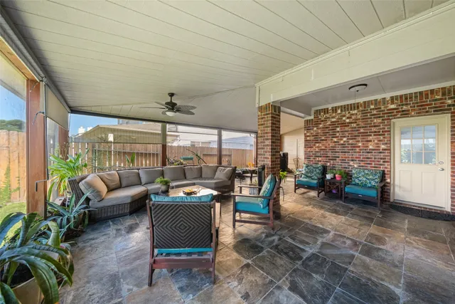 a living room with patio furniture and a potted plant