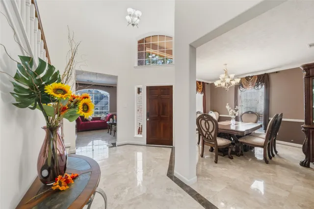 a dining room filled with furniture and potted plants