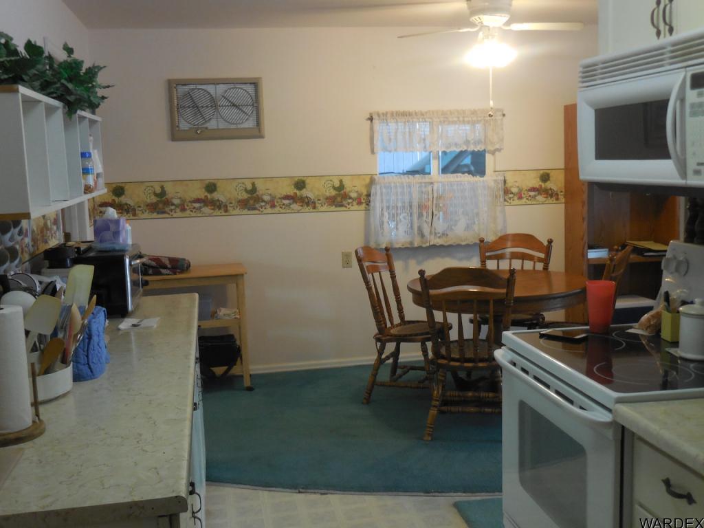 708 Ocotillo Lane Quartzsite, AZ 85346 - Photo 9 of 17 a view of a workspace and kitchen with furniture and wooden floor