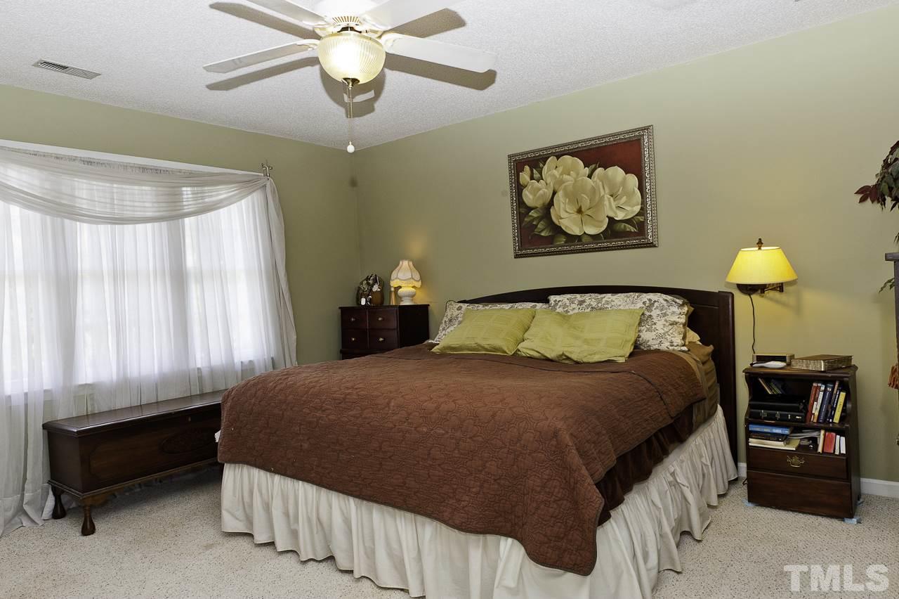 4517 Birmingham Way Raleigh, NC 27604 - Photo 15 of 25 a bedroom with a bed and a chandelier