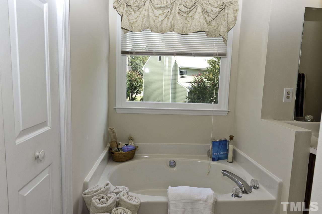 4517 Birmingham Way Raleigh, NC 27604 - Photo 17 of 25 a bathroom with a tub sink and a window