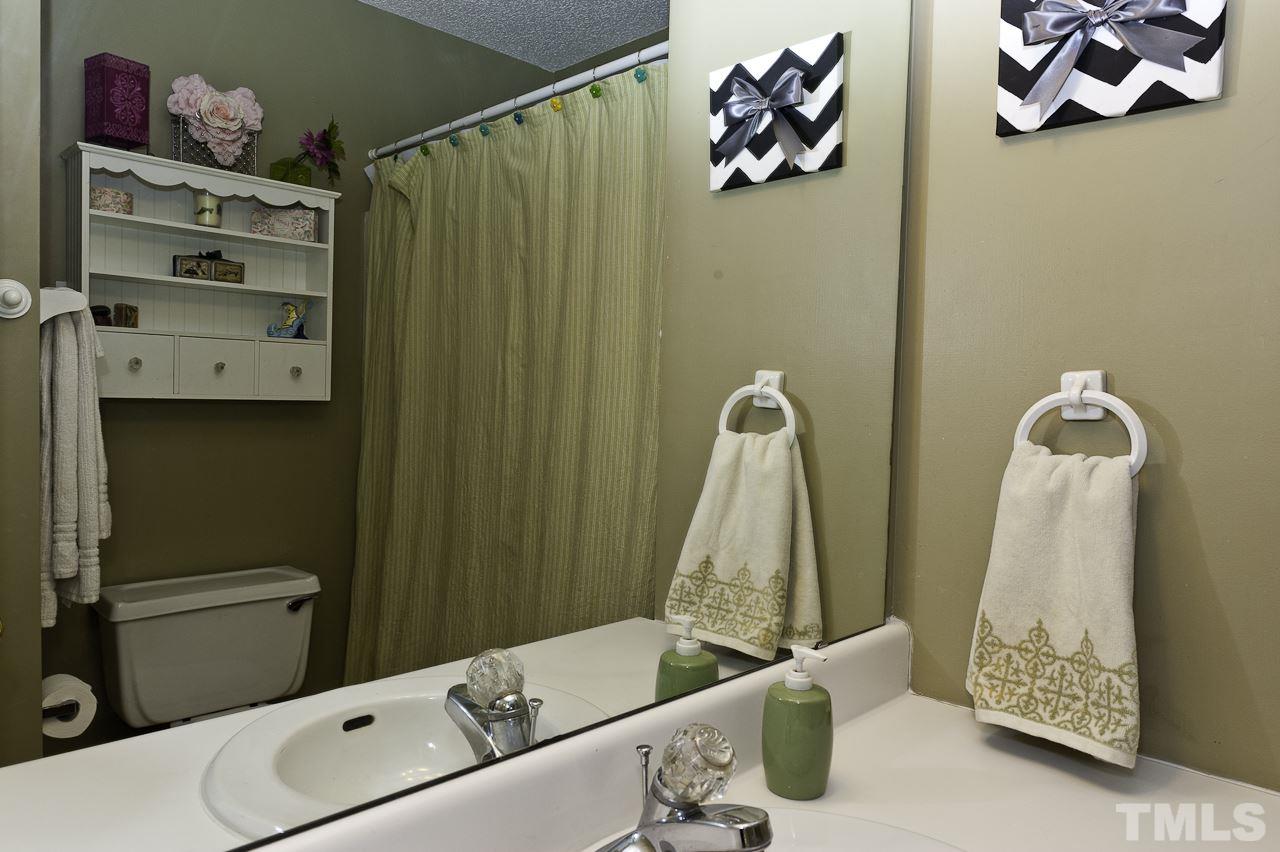 4517 Birmingham Way Raleigh, NC 27604 - Photo 22 of 25 a bathroom with a sink and mirror