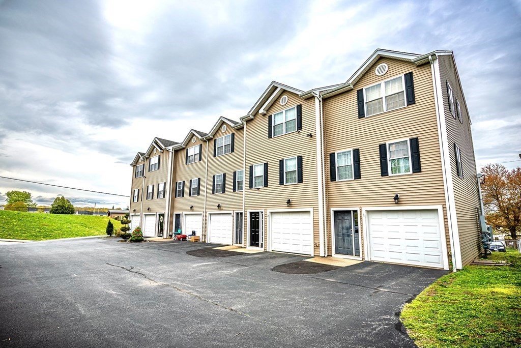 1084 Pine Street, Unit 2 Fall River, MA 02723 - Photo 2 of 22 a view of a white house with a yard and plants next to a road