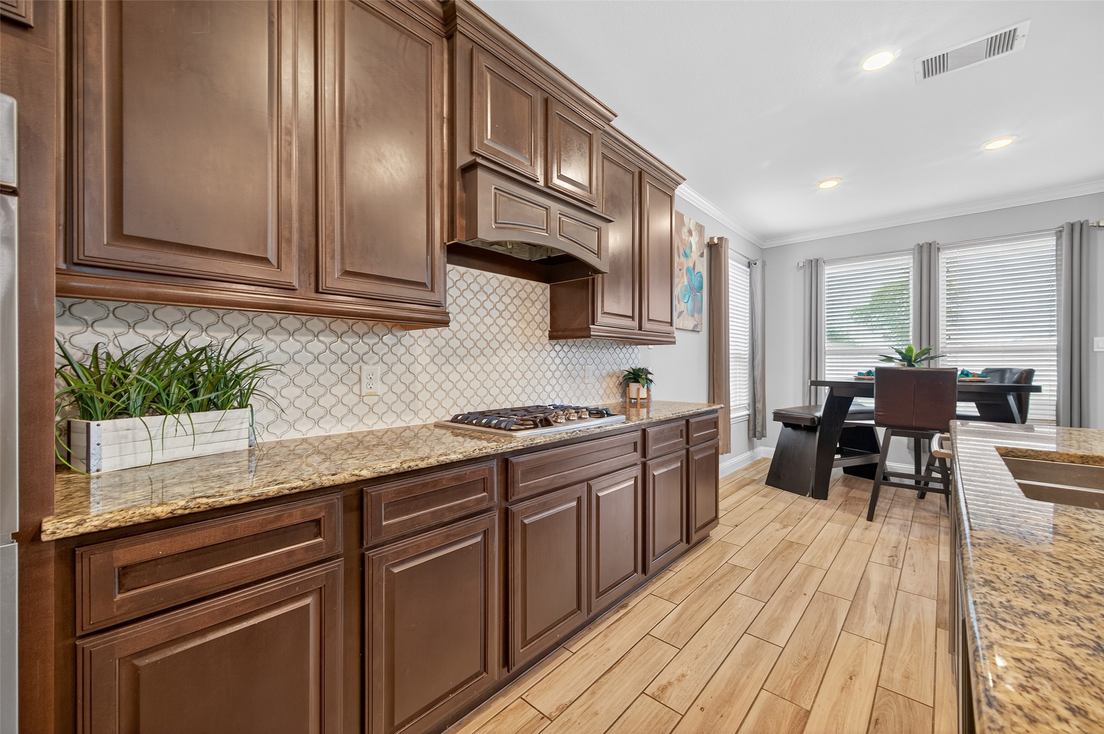 4719 Prairie Springs Lane Rosharon, TX 77583 - Photo 11 of 33 a kitchen with stainless steel appliances granite countertop wooden cabinets a sink dishwasher a stove and a refrigerator with wooden floor