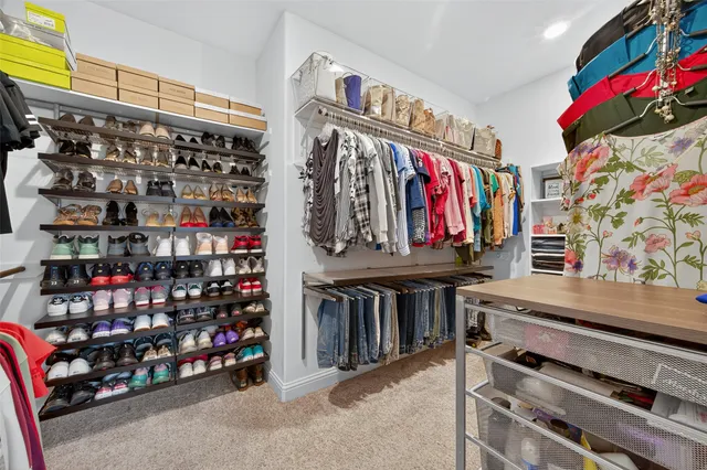 a view of walk in closet with clothes and shoes