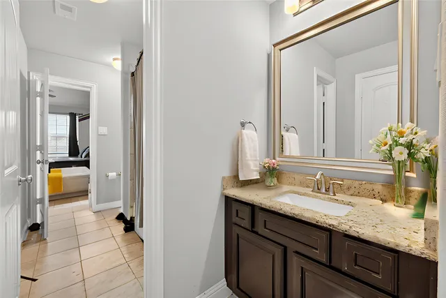 a bathroom with a granite countertop sink and a mirror