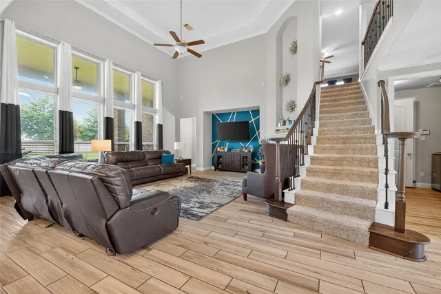 a living room with couches and stairs with wooden floor