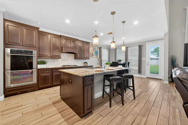 a kitchen with kitchen island granite countertop wooden cabinets and a stove